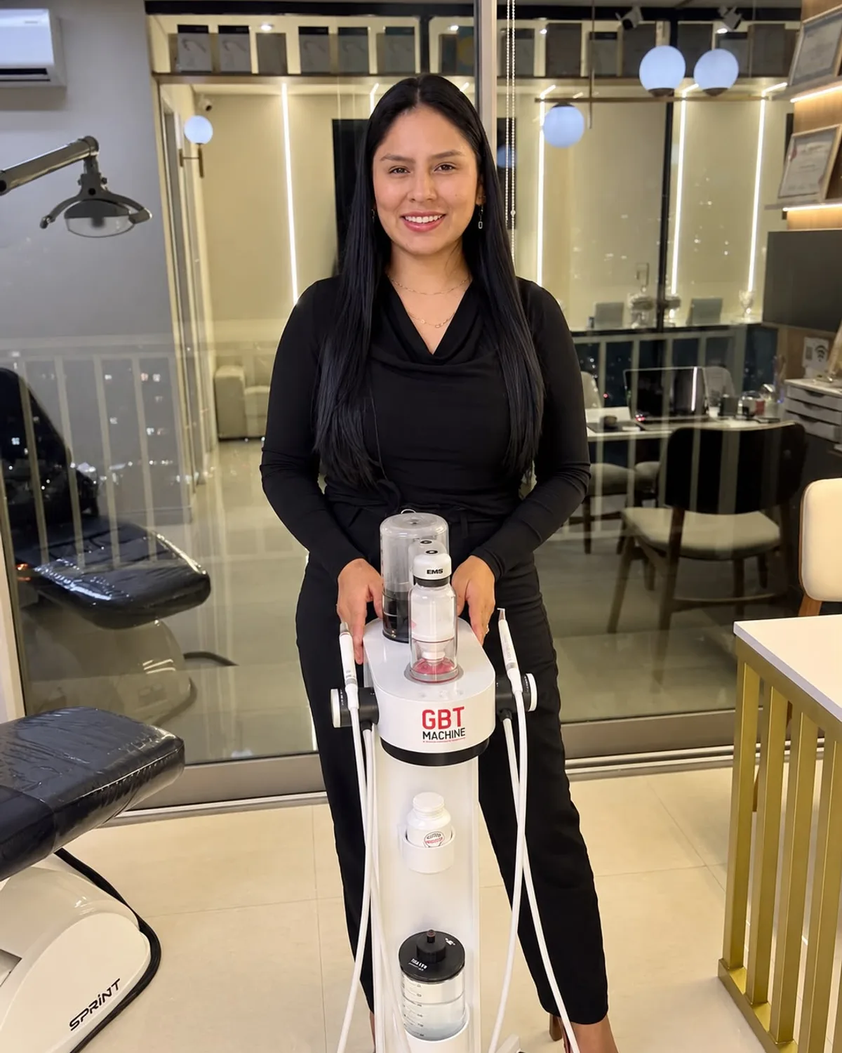 Dra. Mariela Baltazar ao lado do equipamento de limpeza dental GBT (EMS) — limpeza dental de alto padrão no Tatuapé
